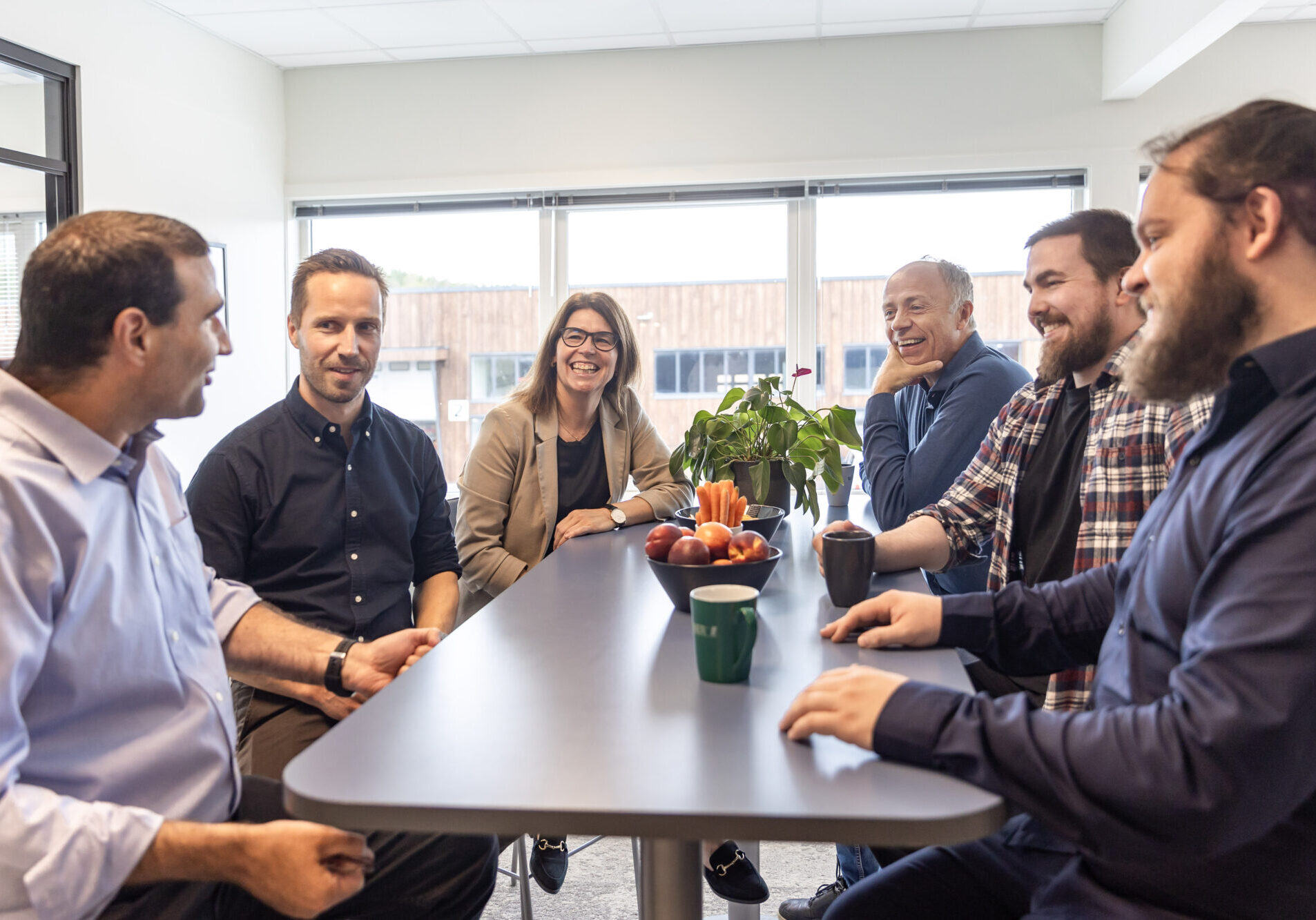 Employees talking and laughing while drinking coffee