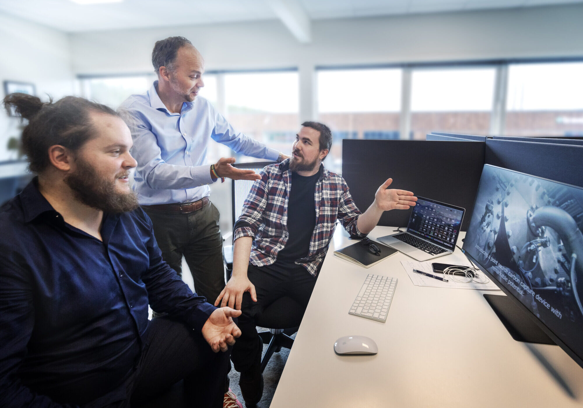 People discussing while looking at a computer screen